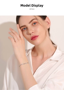Delicate 925 sterling silver heart bracelet worn on wrist with silk shirt detail