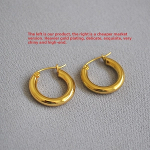 Close-up of thick gold-plated hoop earrings with polished finish and secure clasps