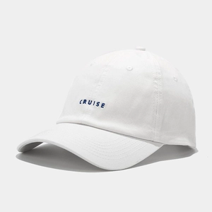 Detail of white cotton baseball cap with navy blue CRUISE embroidery and curved brim