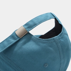 Close-up of peacock blue baseball cap with adjustable matte silver metal buckle
