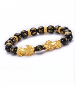 Close-up of 10mm natural black agate beads and golden Pixiu charm on a feng shui bracelet