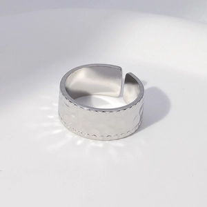 Close-up of silver hammered wide band ring with delicate beaded edges and open design