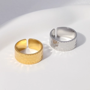 Detailed close-up of hammer textured stainless steel open rings in gold and silver finish