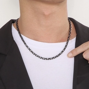 Detail of 4mm Byzantine chain in black and silver steel worn by a male model