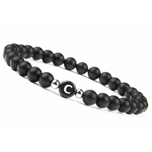 Detail of 6mm matte black onyx bead bracelet with a white letter C and silver spacers