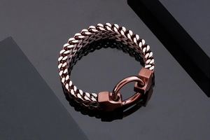 Detailed close-up of heavy duty copper-tone stainless steel Cuban link bracelet with ring clasp
