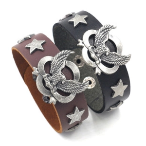 Detail of vintage braided leather bracelets with eagle emblem and star studs decoration