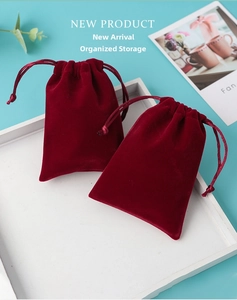 Macro shot of burgundy velvet jewelry pouches with drawstrings on a white wooden tray