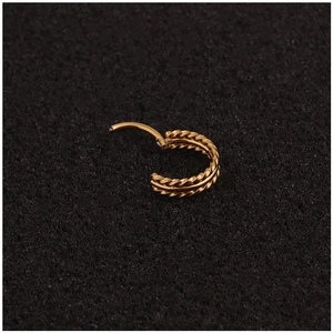 Single gold twisted rope textured hoop earring with hinged closure on dark background