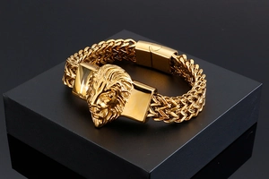 Detailed close-up of golden lion head bracelet on black stand with vintage steel texture