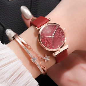 Gros plan d'une montre Tadi avec bracelet en cuir rouge et ensemble de bracelets étoiles