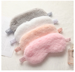 Macro detail of four plush rabbit fur sleep masks in grey, white, and pink tones