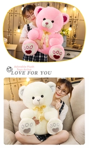 Detail of plush teddy bears in pink and cream with embroidered hearts and LOVE ribbons