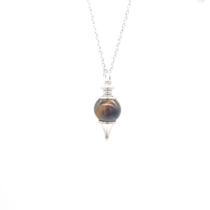 Macro shot of tiger eye stone pendant with a silver metal cone base and fine link chain