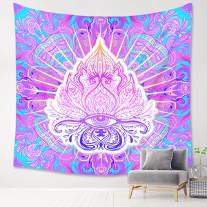 Detail of bohemian mandala tapestry with eye motif hanging above a grey sofa