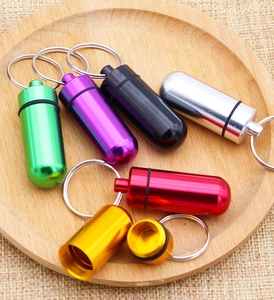 Close-up of waterproof aluminum pill box keychains with rubber sealing rings in various colors