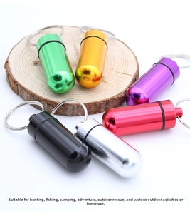Waterproof aluminum medicine capsule keychain in six metallic colors on a wood stand