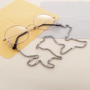 Detail of silver snake chain eyewear strap on round golden glasses with microfiber cloths