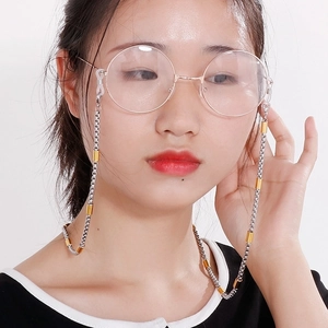 Professional bicolor stainless steel eyewear chain with metal tubes on a female model