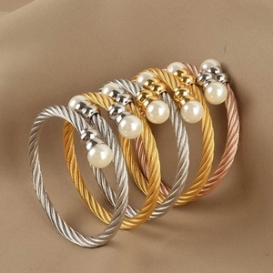 Five twisted cable open bangles in gold, silver, and rose gold with white pearls