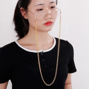 Detail view of a fine gold metal glasses chain with silicone anti-slip loops on model