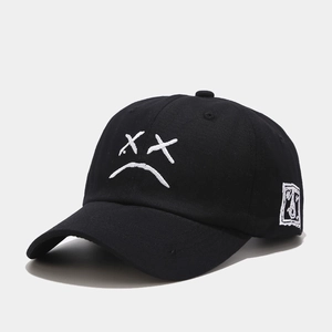 Primer plano de gorra de algodón negro con bordado de cara triste y detalle en el lateral