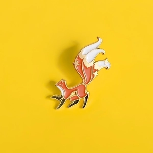 Cute cartoon orange and white fox enamel brooch with a curled tail on yellow background