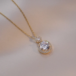 Elegant gold double halo necklace featuring round brilliant crystals on silk background