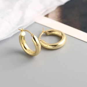 Close-up of chunky gold hoop earrings with a polished finish and minimalist design