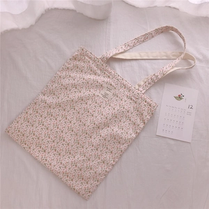 Close-up of floral cotton tote bag with cream fabric and vintage flower pattern detail