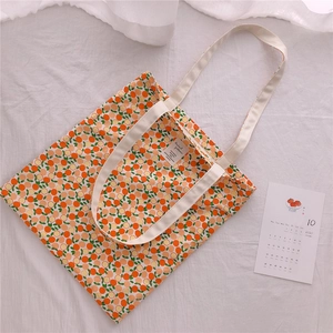 Detail of floral cotton tote bag with orange fruit print and cream canvas straps