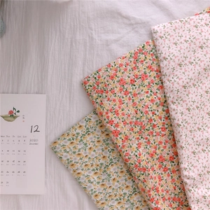 Detailed view of floral cotton fabric patterns in ginger, orange and creamy white colors