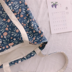 Detail of floral canvas tote bag showing thick cotton handles and blue floral pattern