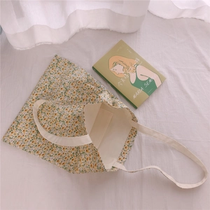 Detail of floral canvas tote bag featuring interior pocket and yellow flower pattern
