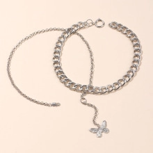 Detail of silver double-layered chain bracelet featuring a delicate butterfly pendant