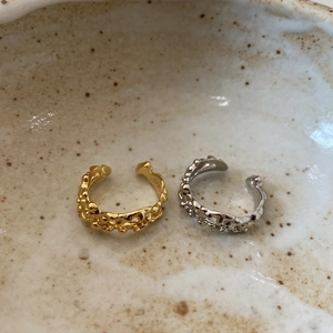 Detail of gold and silver irregular lava S925 sterling silver rings in a ceramic bowl