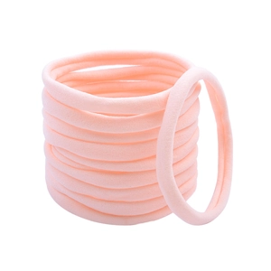 Macro shot of seamless pink nylon hair ties showing high elasticity and soft texture