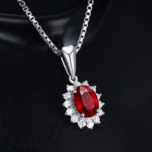 Macro view of oval red ruby pendant with sparkling white diamond halo on a box chain