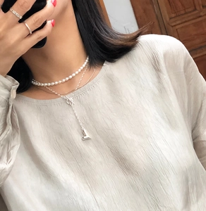 Detail of layered 925 silver heart pendant necklace with delicate freshwater pearls
