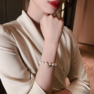 Elegante vergulde armband met zoetwaterparels gedragen om de pols van een vrouw