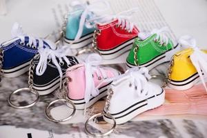 Detailed close-up of mini colorful canvas shoe keychains with realistic laces and soles