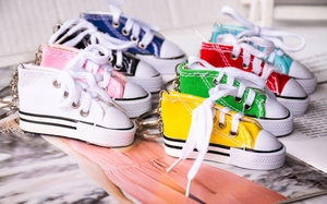 Miniature canvas shoe keychains in eight vibrant colors showing detailed stitching and laces