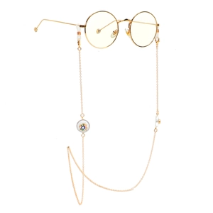 Golden round glasses chain featuring evil eye pendants and faux pearls on white background