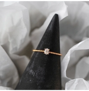 Detailed view of oval zircon set on twisted titanium steel band with 18K gold plating