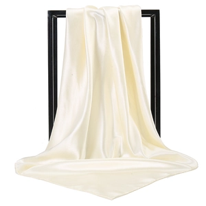 Detail showing creamy white satin silk square scarf draped on black minimalist frame