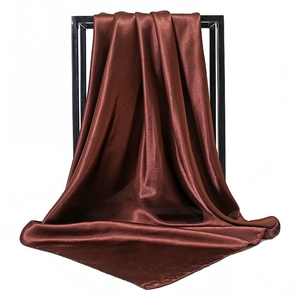 Detail of dark brown satin square scarf with smooth silk texture on black metal frame