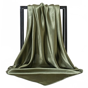 Detail of olive green satin silk scarf draped over a black frame with smooth texture
