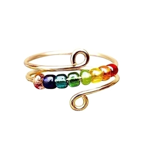 Detail of adjustable ring featuring seven colorful rotating beads in a rainbow sequence