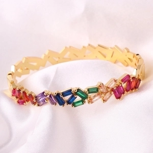 18k gold plated rainbow bracelet with multi-colored rectangular gemstones on white satin