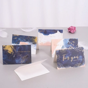 Detail of elegant greeting cards with watercolor designs and gold geometric foil lines